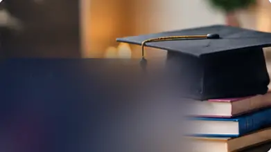 قبعة تخرج فوق كومة من الكتب